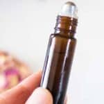 hand holding 10mL amber essential oil roller bottle