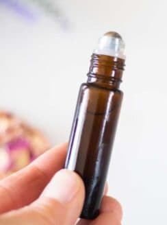 hand holding 10mL amber essential oil roller bottle