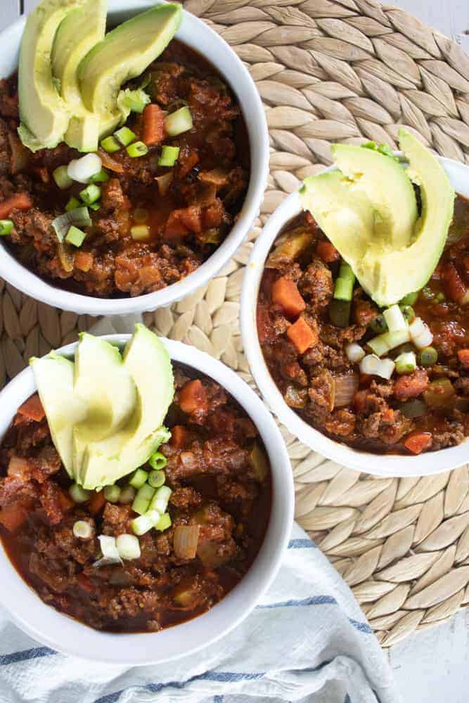 three bowls of whole30 chili on wicker background