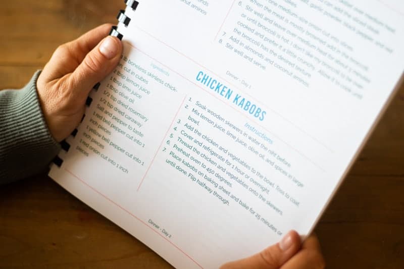 healthy meal prep recipe book on wooden table. 