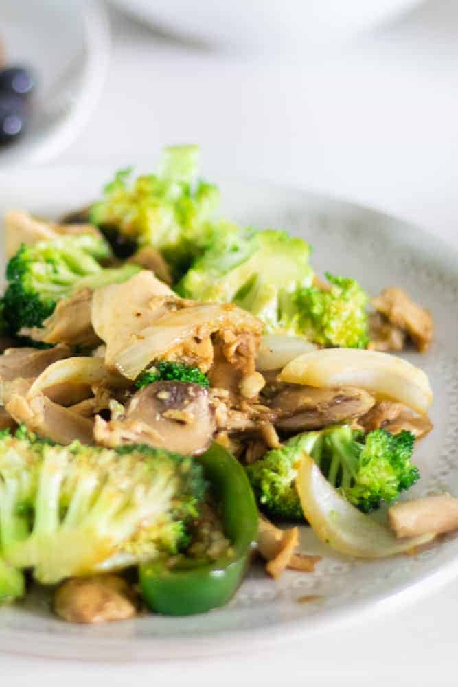 broccoli stir fry with chicken on white plate for a on the go meal.