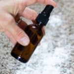 Amber colored bottle spraying on carpet over baking soda.