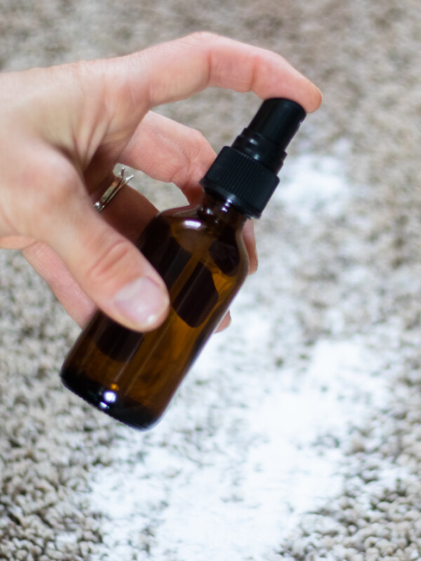 Amber colored bottle spraying on carpet over baking soda.