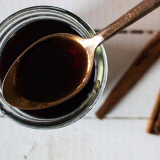 elderberry syrup on gold spoon over mason jar