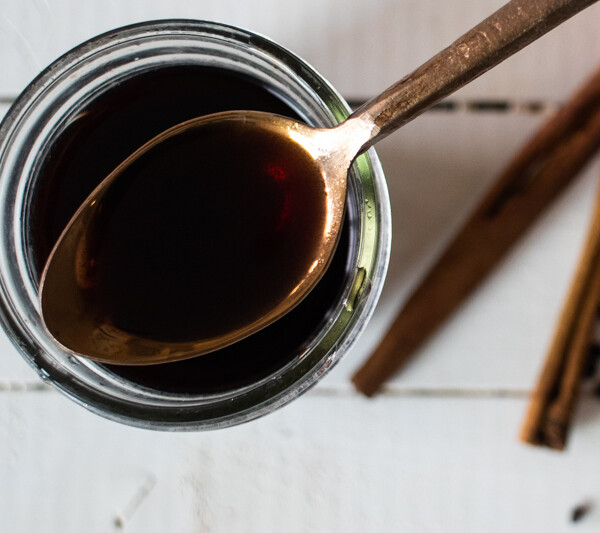 elderberry syrup on gold spoon over mason jar