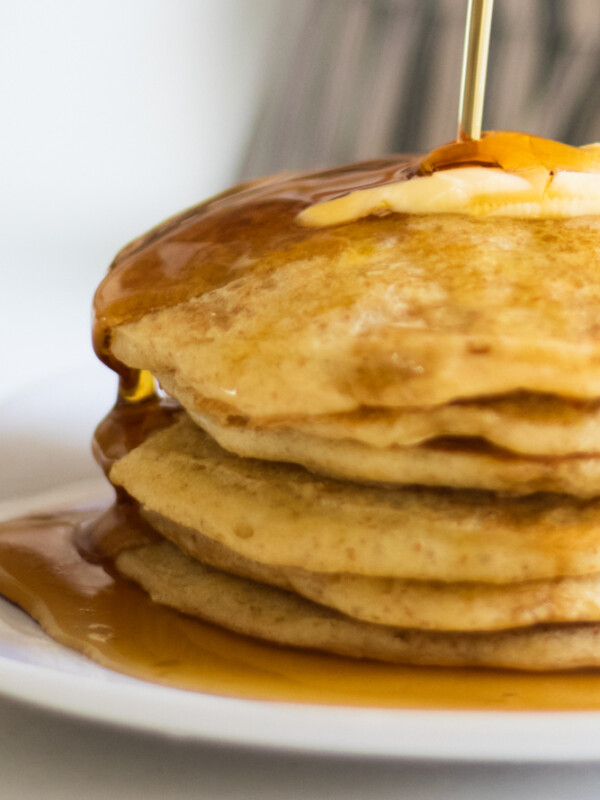 Sourdough pancakes topped with butter and maple syrup.