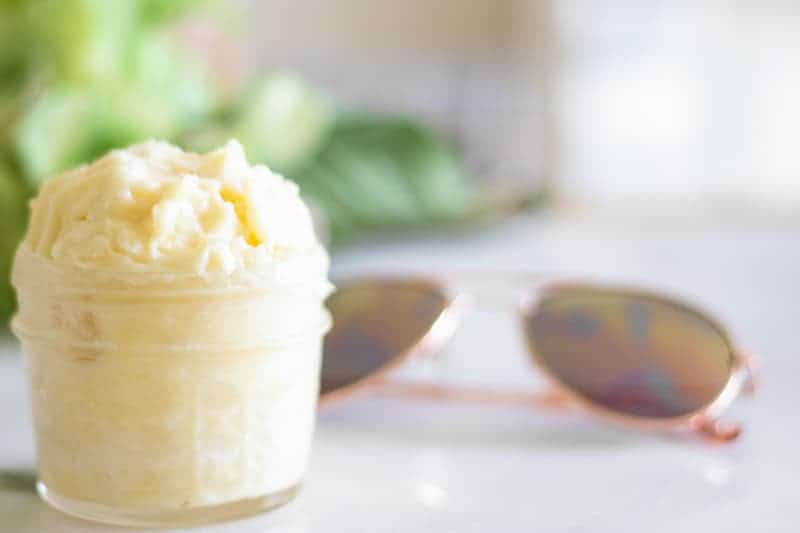 homemade after sun lotion in small mason jar with pink sunglasses