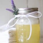 DIY bubble bath ingredients in mason jar with a sprig of lavender.