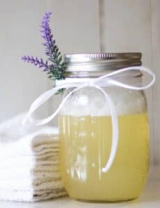 DIY bubble bath ingredients in mason jar with a sprig of lavender.