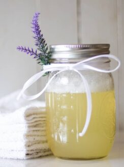 DIY bubble bath ingredients in mason jar with a sprig of lavender.