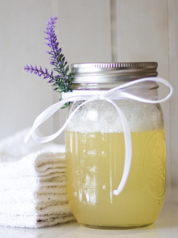 DIY bubble bath ingredients in mason jar with a sprig of lavender.