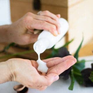 diy body wash in white container pouring into hand