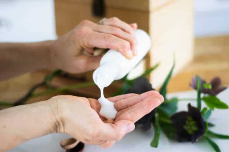 diy body wash in white container pouring into hand