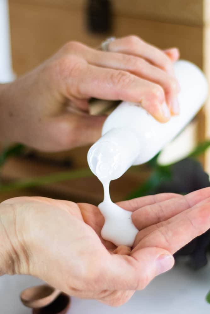 hand pouring shower gel into other hand