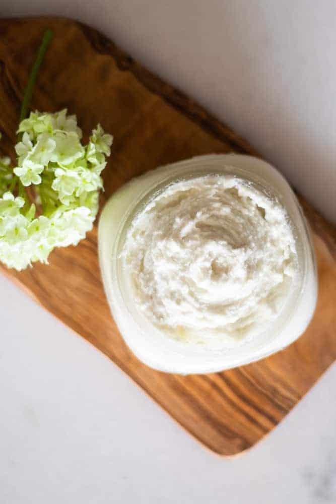 whipped homemade lotion on wooden cutting board