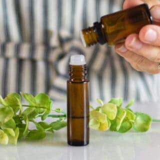 hand dropping essential oils into roller bottle