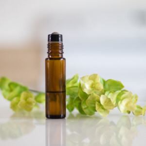 amber colored roller bottle with green plant