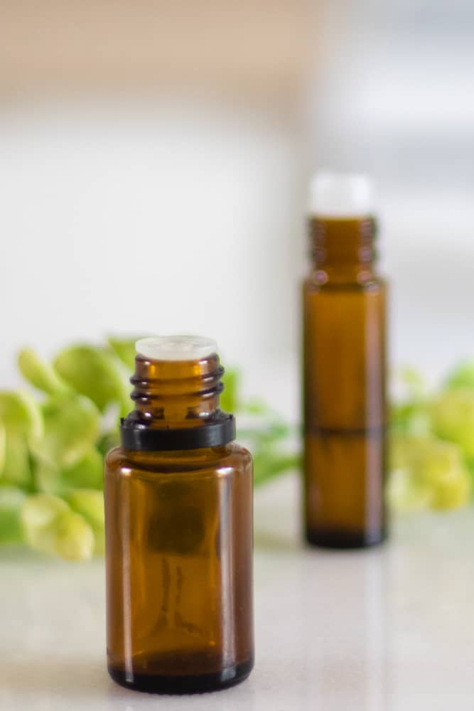 essential oil bottle with roller bottle for making bug bite itch relief in background.