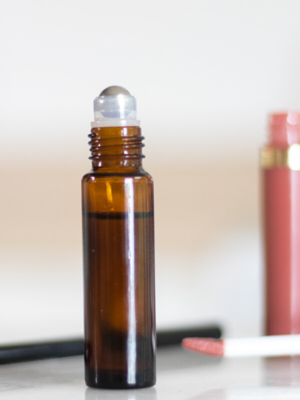 amber color essential oil roller bottle with white background