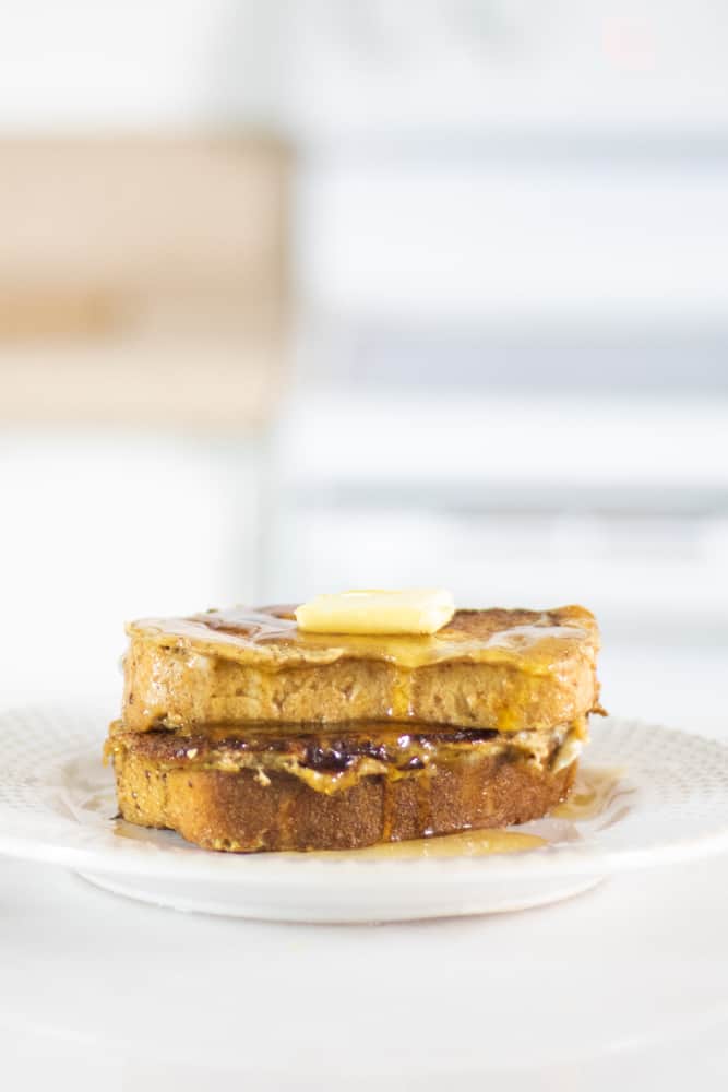 homemade sourdough French toast on white plate on white marble