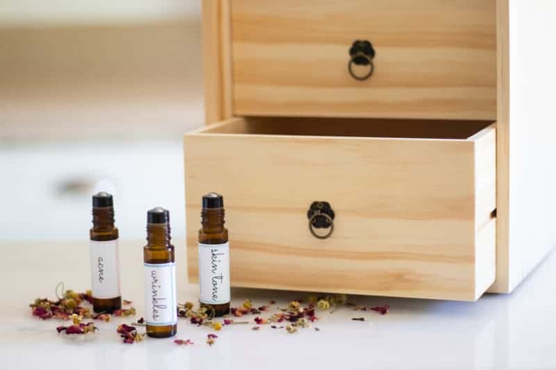 roller bottles in front of wooden essential oil storage box