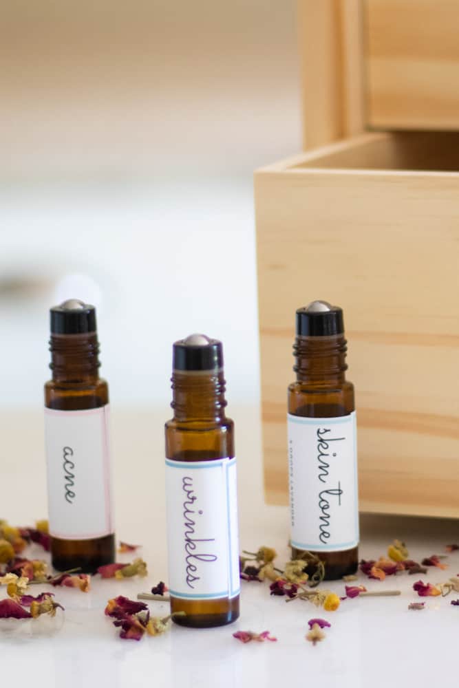 amber colored roller bottles with white labels surrounded by dried herbs