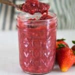 Healthy strawberry jam in a glass mason jar.