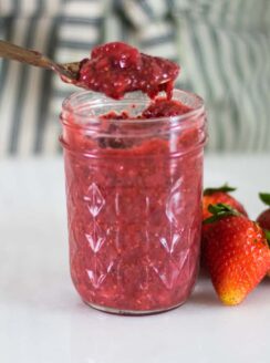 Healthy strawberry jam in a glass mason jar.