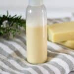 homemade shampoo in bottle sitting on white and gray striped towel