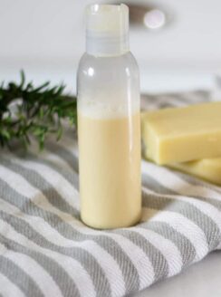 homemade shampoo in bottle sitting on white and gray striped towel