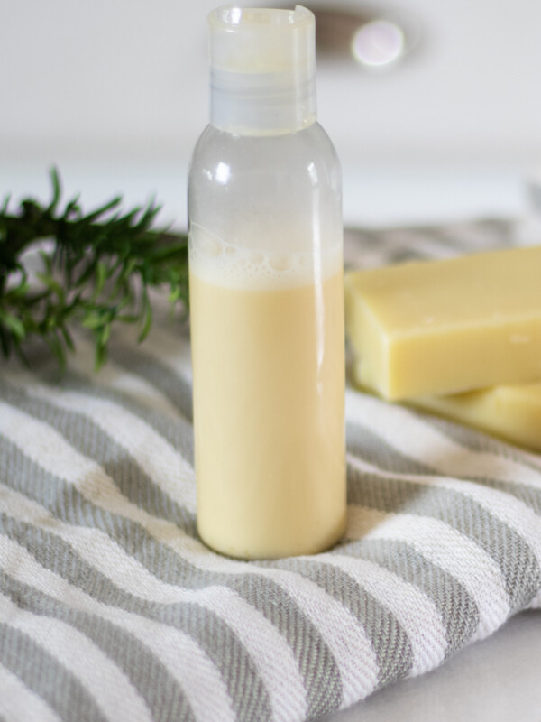 homemade shampoo in bottle sitting on white and gray striped towel