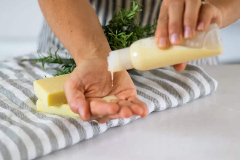 pouring shampoo onto hand above white table