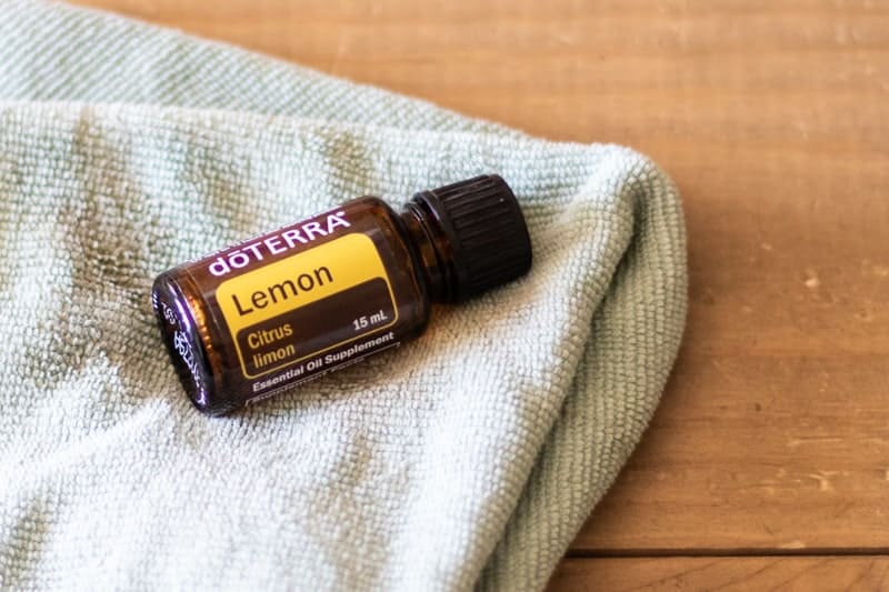 lemon essential oil and green cloth on wooden coffee table