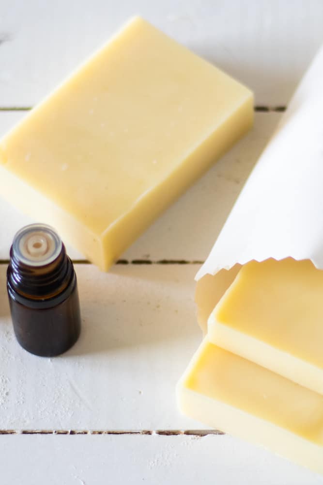 homemade conditioner bars in little white bag on white shiplap table.