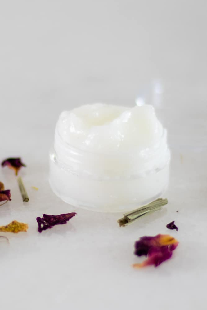 natural diy eye cream in small plastic container on white table