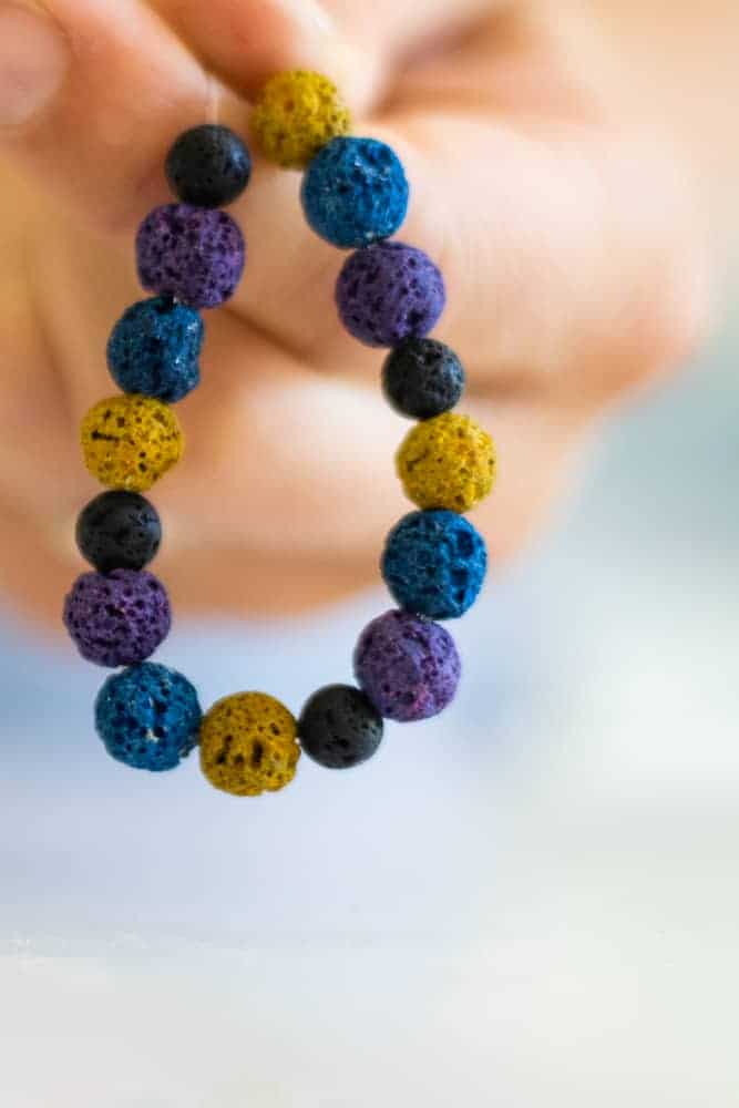 Holding multi-colored handmade diffuser bracelet