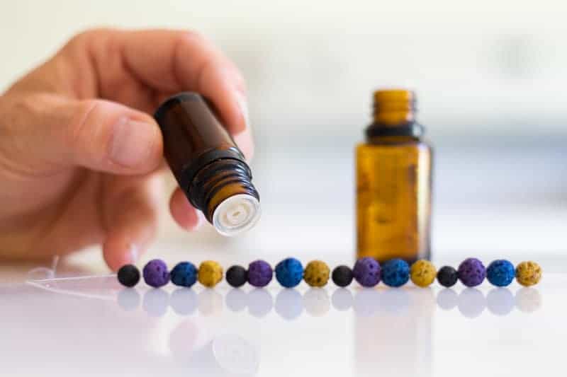 Adding oils to homemade bug repellent diffuser bracelet.