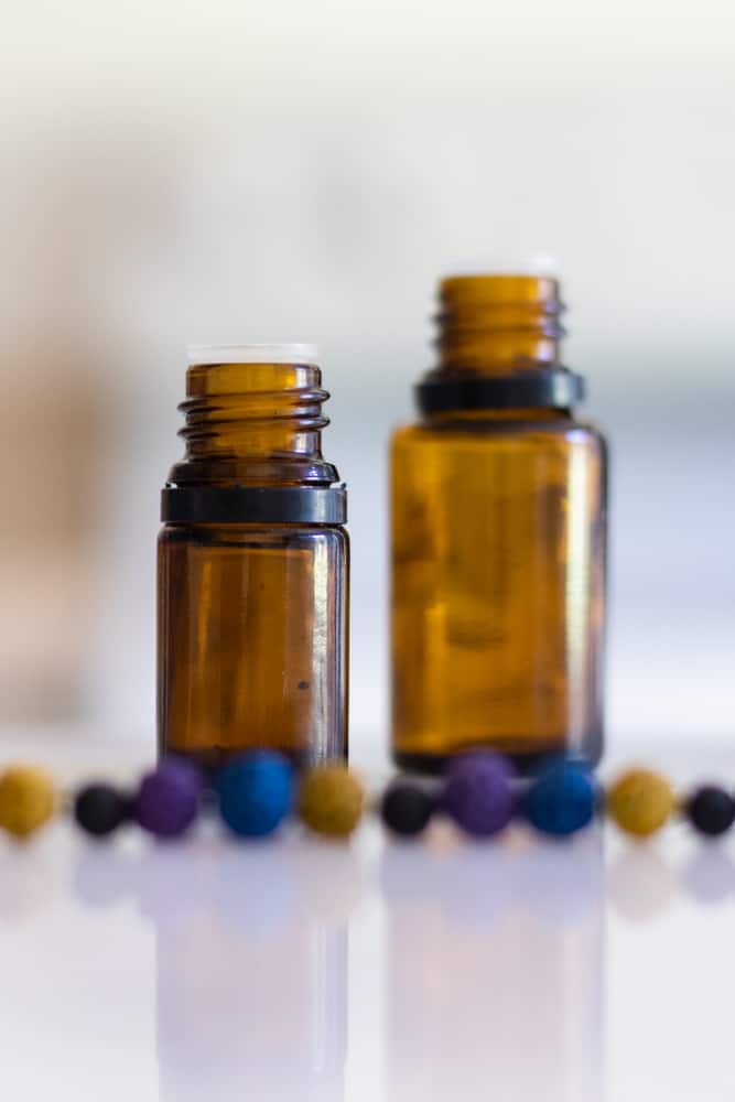 amber colored essential oil bottles behind oil diffuser bracelet