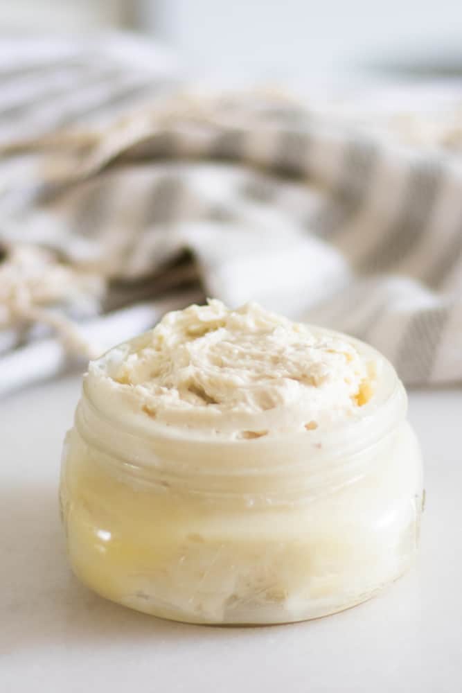 stretch mark cream in mason jar and decorative towel in background