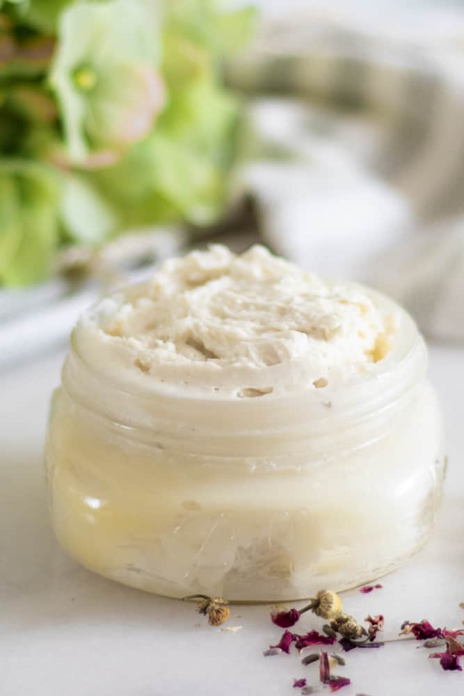 creamy stretch mark lotion in mason jar with lavender sprigs