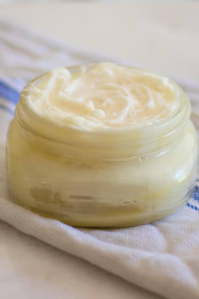 whipped mango body butter in mason jar on tea towel