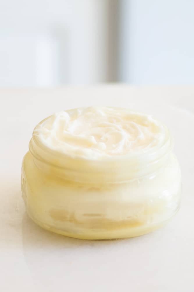 mango body butter lotion in wide mouth mason jar on marble counter