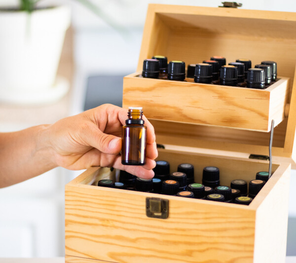 women pulling essential oil out of wooden oil storage box