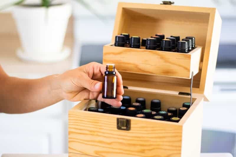 Taking essential oil bottle from wooden oil storage box