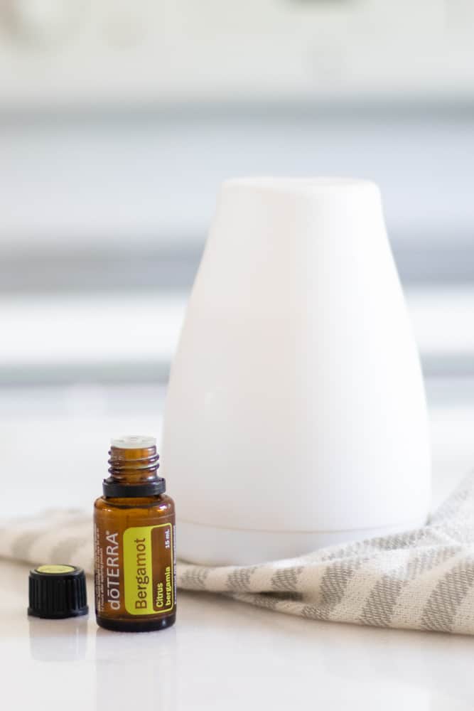 bergamot oil and white diffuser on white marble