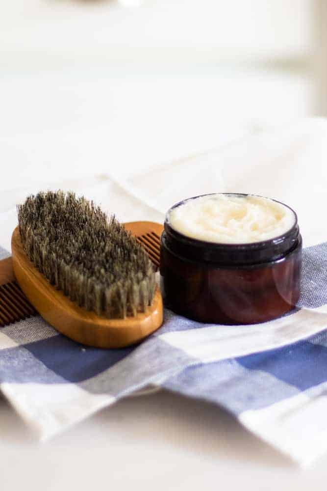 beard conditioner in amber colored container on blue checked tea towel