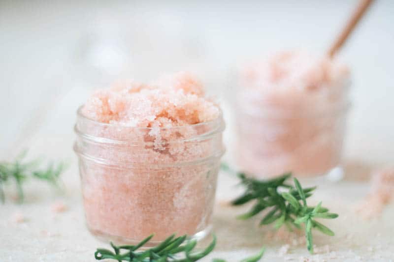 Pink Himalayan foot scrub in jar on white marble.