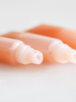 three tubes of pink lip gloss