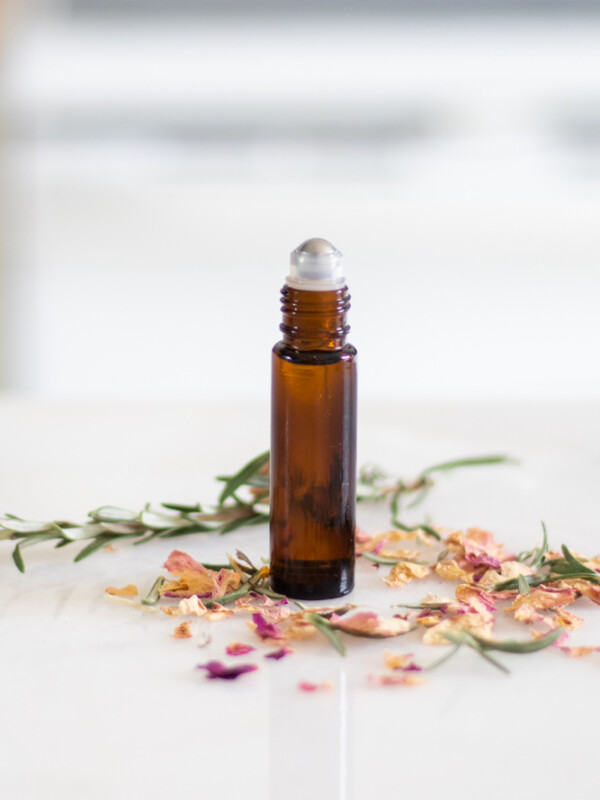 essential oil roller bottle on white marble
