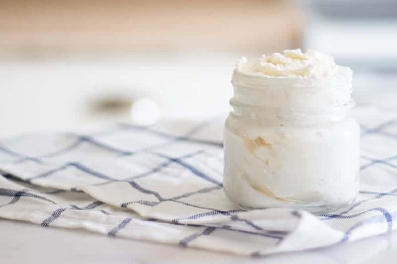 shea butter lotion in mason jar on white and blue towel